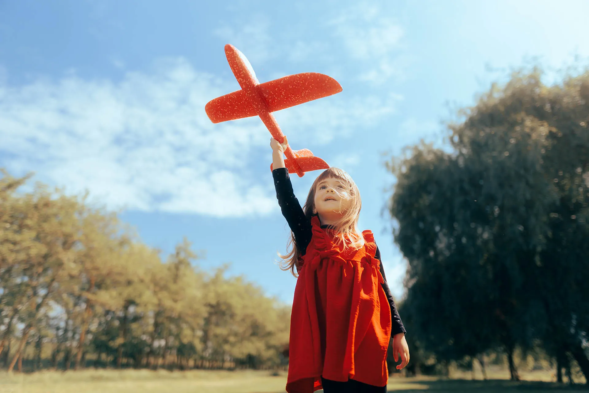 girl outside with toy aeroplane 